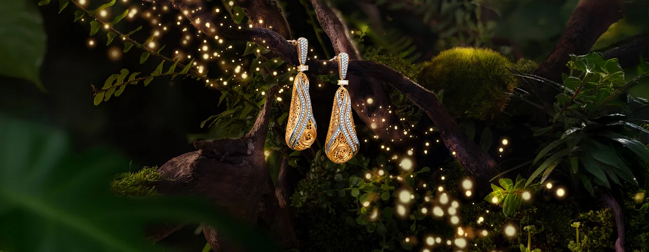 Polki and emerald drop earrings on blue reflective surface.