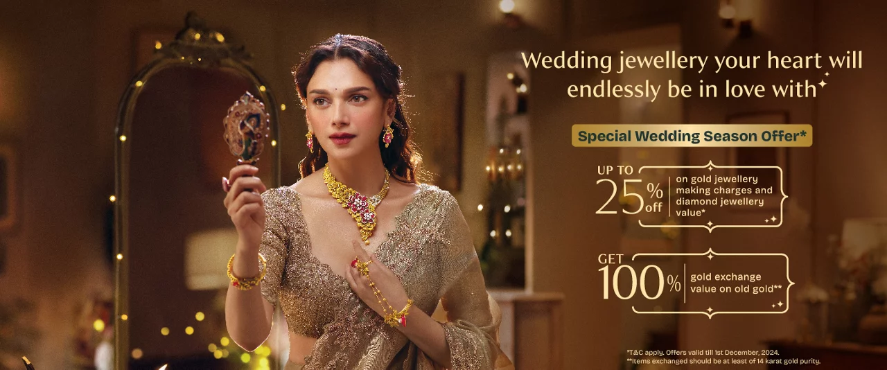 Elegant woman in emerald gold necklace and earrings from Aditya Birla Group