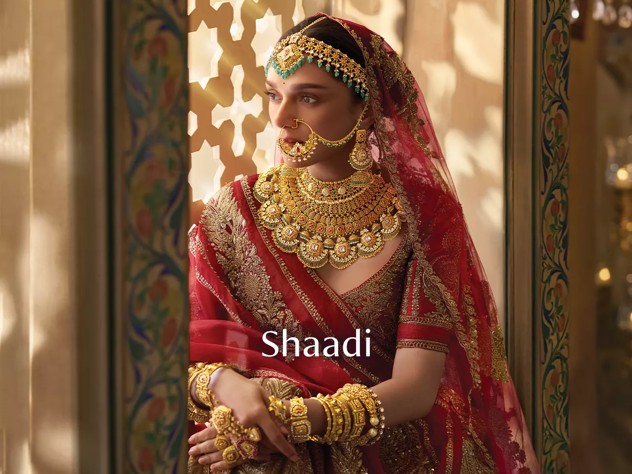 Indian bride in red lehenga with gold jewellery and "Shaadi" text.