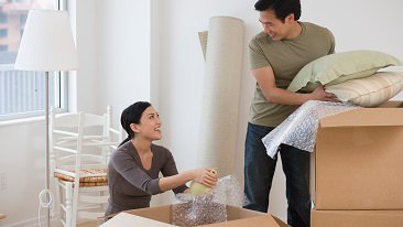 Asian couple unpacking boxes