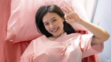 A smiling girl making an OK hand gesture
