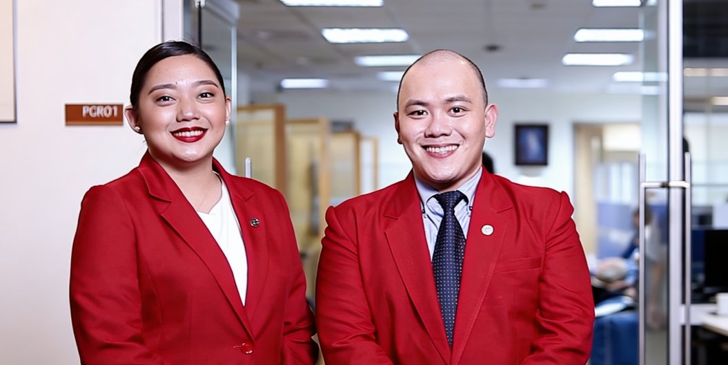 2 people in their red uniform smiling