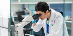 Medical researcher looking through a microscope in a labratory