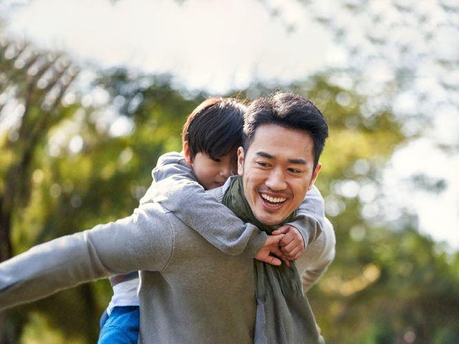 Father carrying his son on his back and enjoying quality time together