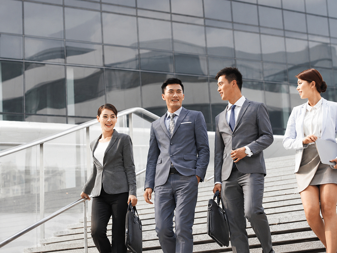 Three business profesionals walking down the stairs