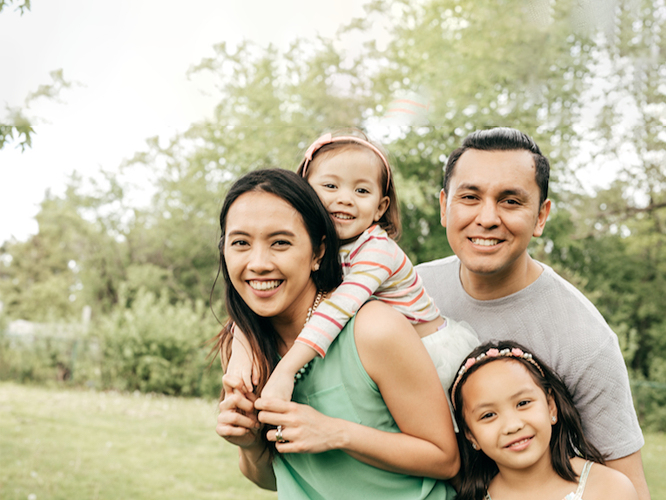 A family of four smiling together