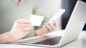 A person holding phone and card