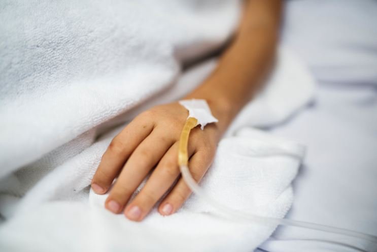 A close-up of a person’s hand with an IV drip