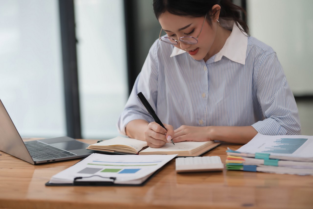Young hardworking businesswoman writing her idea before the meeting.