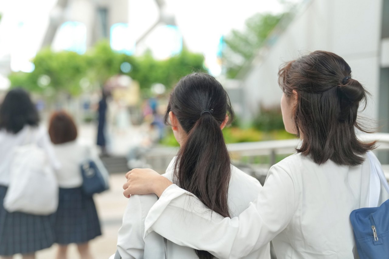 In early June in Shanghai, Japanese high school girls in uniforms walk through the streets near The Bund, their uniforms and cheerful mood adding youthful charm to the city's iconic riverside view.