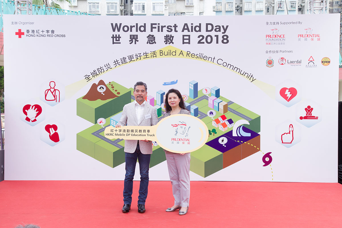 保誠行政總裁容佳明先生（左）與香港紅十字會主席胡郭秀萍女士（右）於開幕禮中進行車匙轉贈儀式