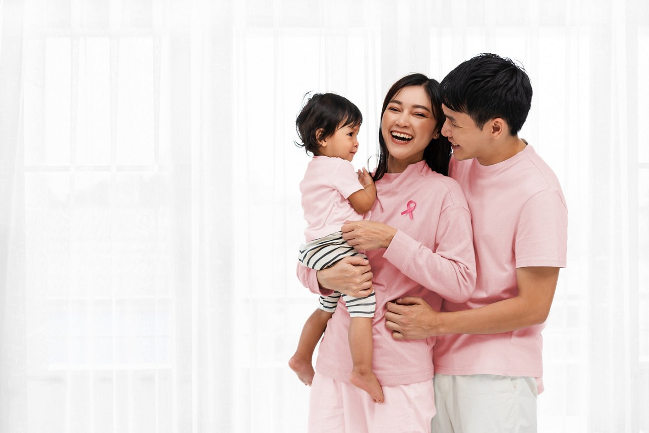 cheerful father and mother holding and hugging with toddler baby on white window background. happy family concept