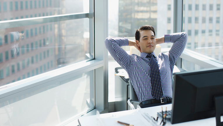 A businessman leaning back in his office chair.