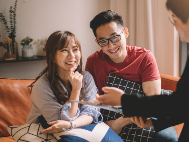 Newlywed couple smiling with wedding bouquet.