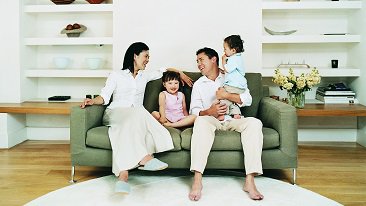 A  family of four sitting on a couch