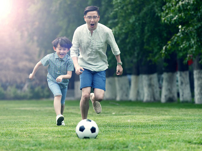 father and son playing soccer