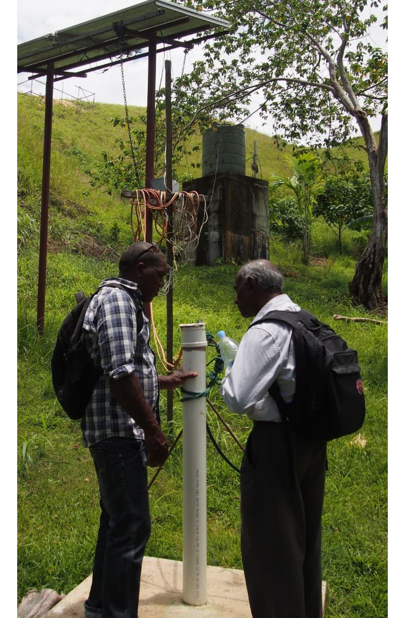 RMIT academic Jega Jegatheesan inspects a borehole with a local community member.  