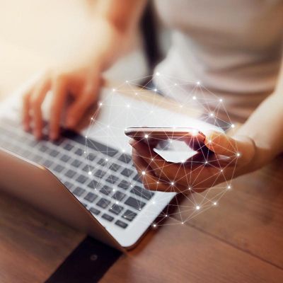 Woman hand using mobile phone and laptop