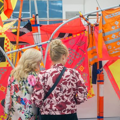 Two women students looking at patterned fabric