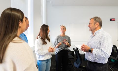 four students speaking with teacher