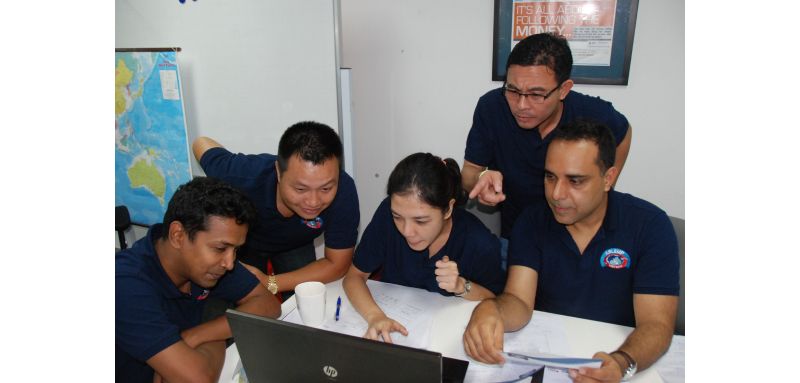 a group of people doing work in front of a laptop 