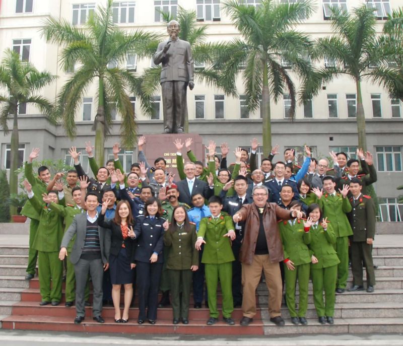 transnational security centre team and police posing in front of a statue