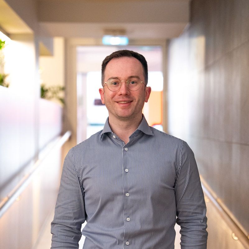 A portrait photograph of Alexander smiling and looking directly at the camera.