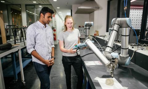 Two students standing in front of a holosense machine