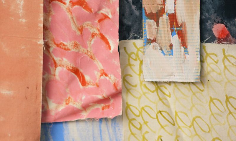 Fabrics overlaid on top of each other, as well as a piece of painted cardboard. There are different patterns and colours on the fabrics – some are light and springy, while others are washes of colour. 