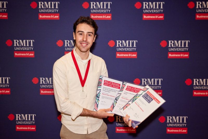 Person holding three certificates in front of dark blue background