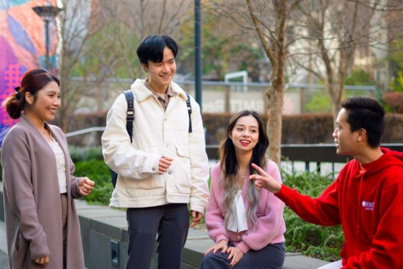 Four people gathering outside with friends talking