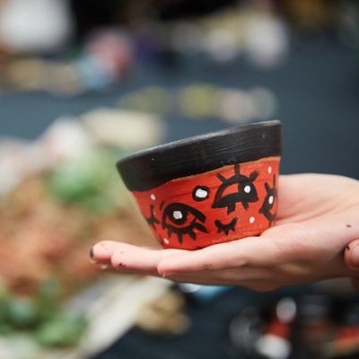 Close up of a hand-painted red and black flower pot.