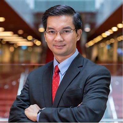 a headshot of an asian man in suit smiling 