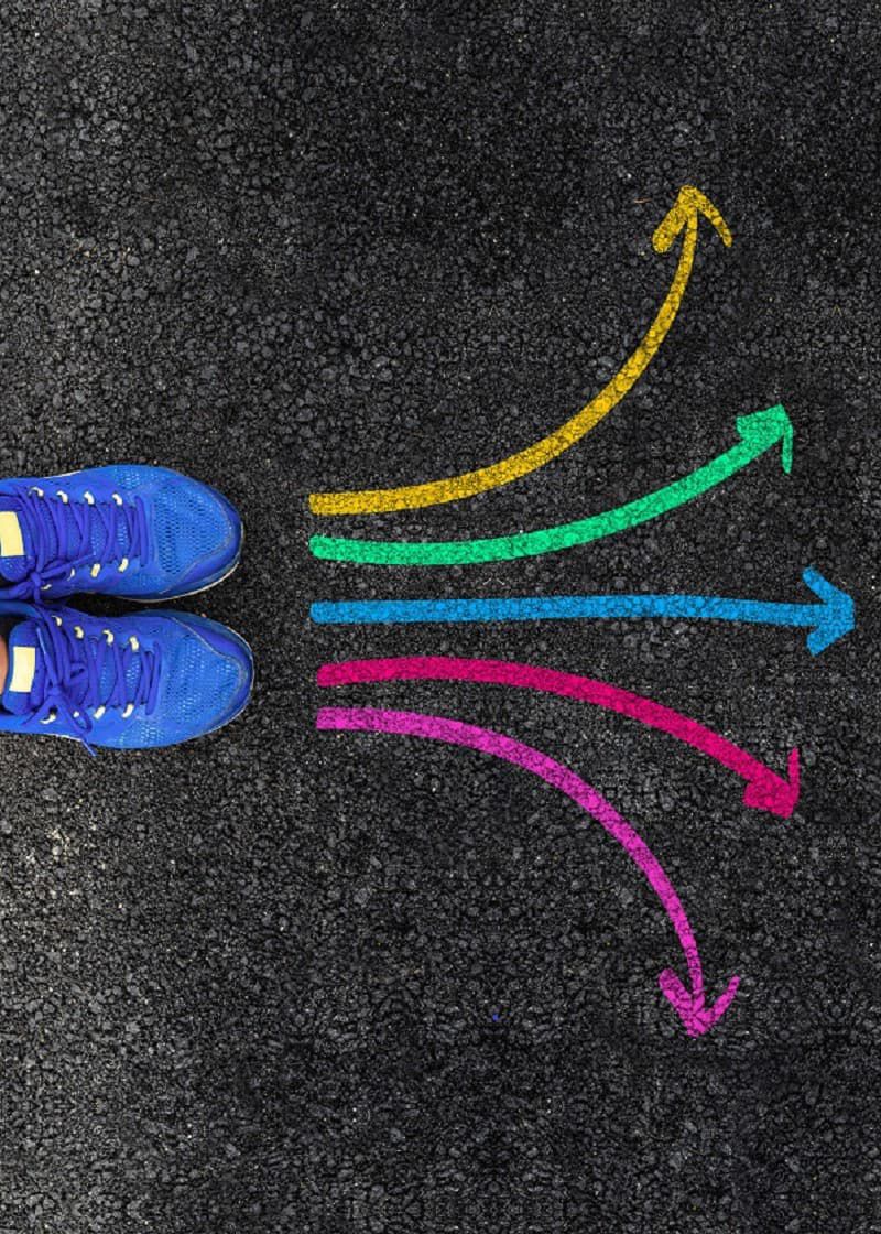 Blue shoes pointed towards multicoloured arrows, each leading in a different direction. 