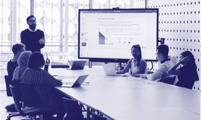 Bachelor of business students sitting around a table while looking at business analytics graphs