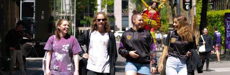 Indigenous students smiling and walking at RMIT City campus