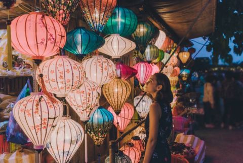 Young Caucasian woman choosing lanterns in Hoi An