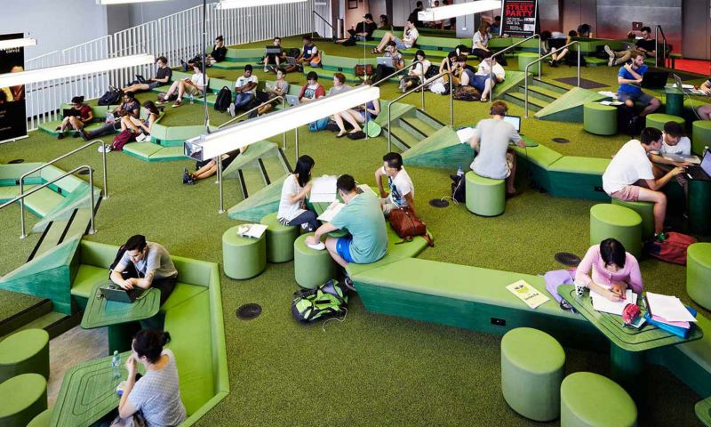 Green space at the City Campus, populated by lounging and studying students.