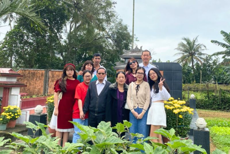 A group of people posing for a photo in a cemetery.