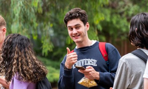Student giving a thumbs up and smiling.