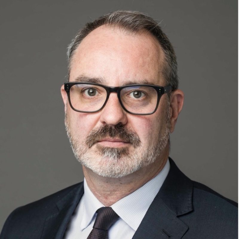 Heath Mcdonald profile photo. He is wearing a suit and glasses.