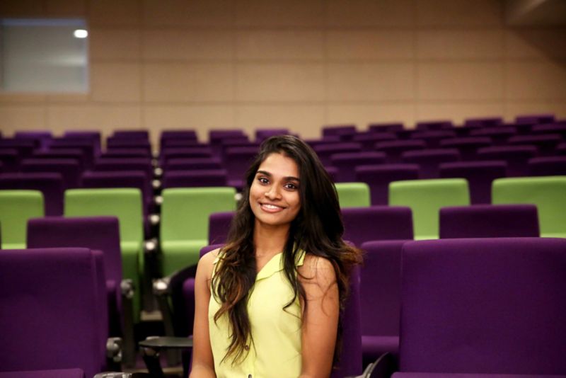 a woman smiling in a lecture hall 