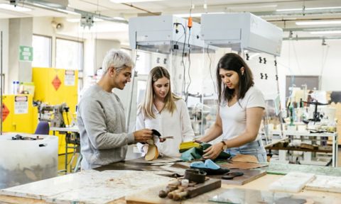 Three RMIT fashion students work together to make a shoe.