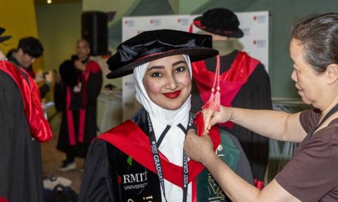 Doctoral degree graduate smiling at camera.