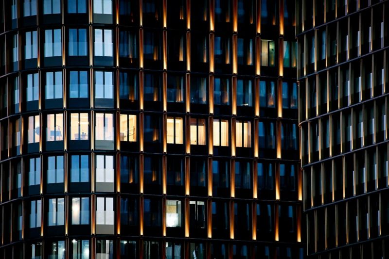 Modern glass building with illuminated windows at night.