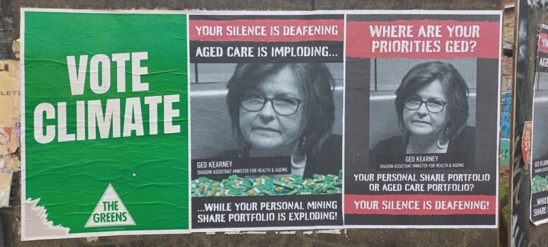 Three gig-style posters on a hoarding.