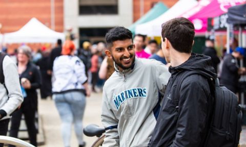 Two male students chat on campus.