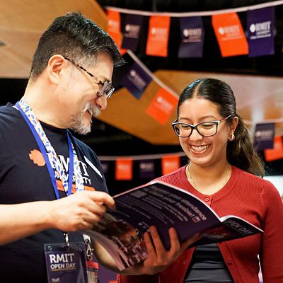 RMIT Staff member and student looking at course guide.