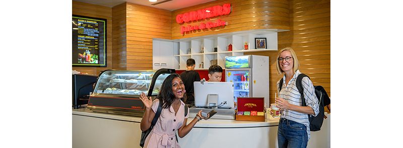 a Sri Lankan student and Danish exchange student outside a cafe kiosk in Saigon South.