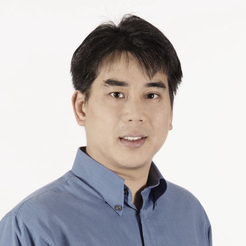 Profile photo of Leslie Yeo smiling towards the camera against a solid white background. Leslie is wearing a blue shirt.